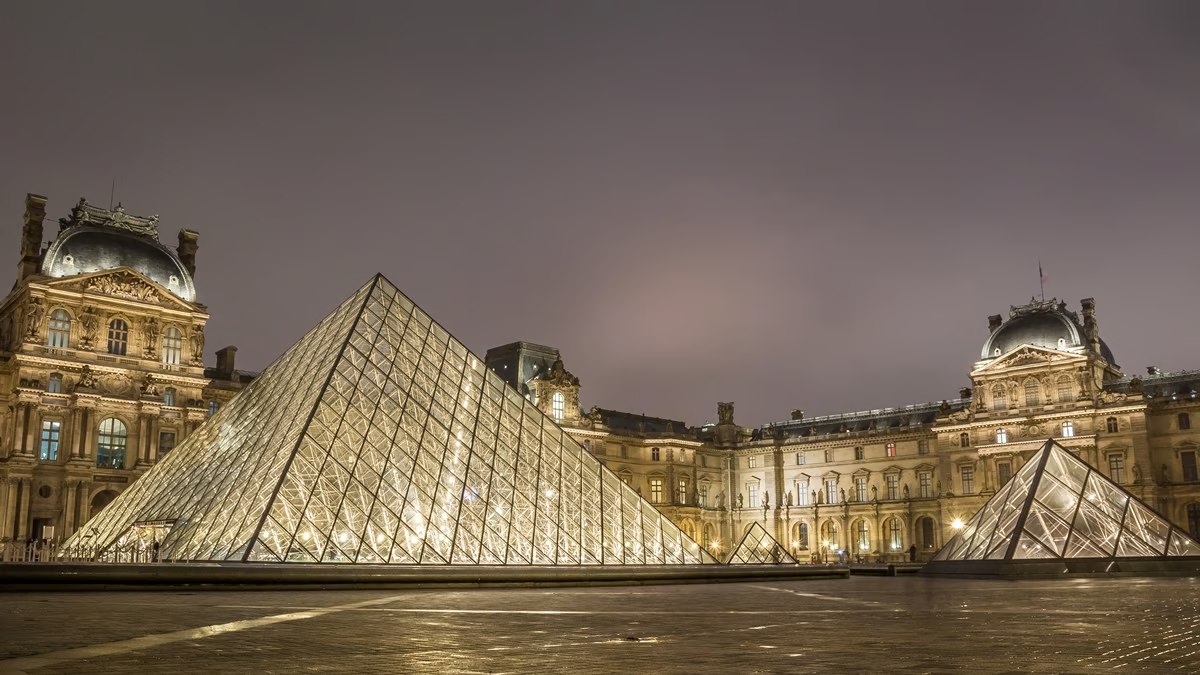 La Pyramide du Louvre avec des structures en acier inoxydable la nuit.